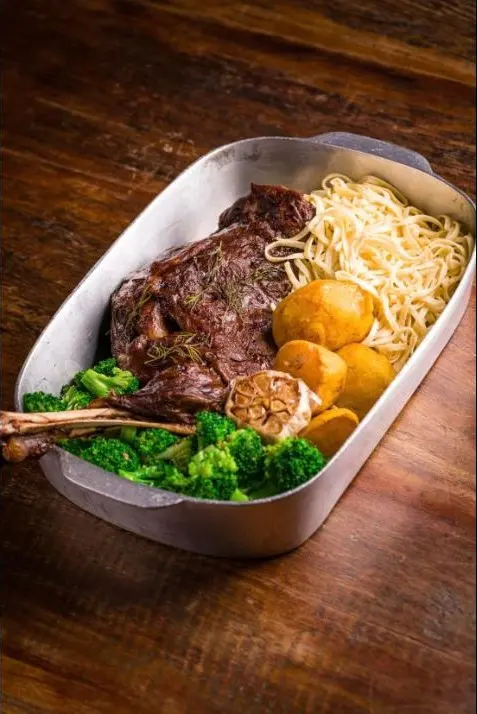 Paleta de cordeiro com tagliarini, batatas e brócolis na travessa